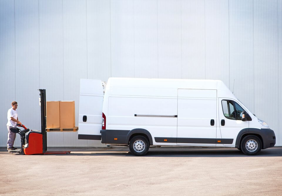 courier delivery service worker loading mail into van for b2b shipment