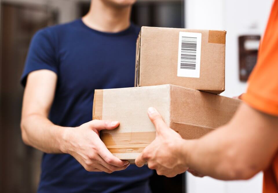 A person wearing an orange T-shirt is delivering parcels to a satisfied client
